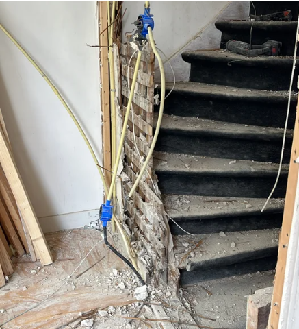Oude trap voor renovatie met leidingwerk Haarlem